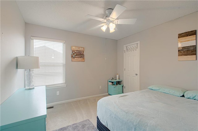 carpeted bedroom featuring ceiling fan, baseboards, and a textured ceiling