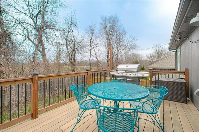 deck featuring outdoor dining space and area for grilling