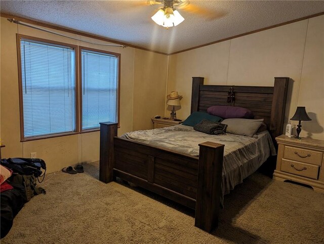 carpeted bedroom with ceiling fan, a textured ceiling, and ornamental molding