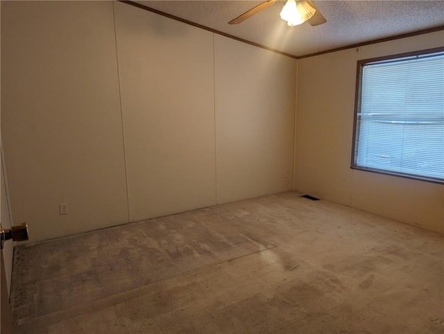 carpeted spare room featuring ceiling fan and a textured ceiling