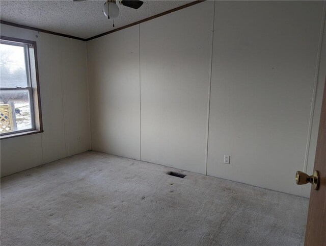 carpeted empty room with a textured ceiling and ceiling fan