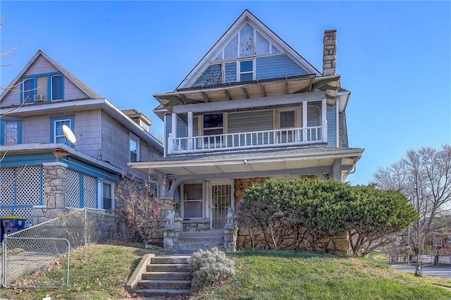 victorian home featuring covered porch and a balcony