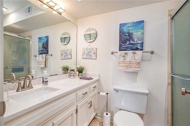 bathroom with tile patterned floors, toilet, vanity, and walk in shower