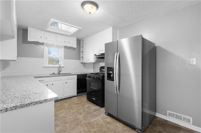 kitchen with black appliances, decorative backsplash, white cabinets, and sink