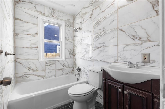 full bathroom with vanity, toilet, tiled shower / bath, and tile walls