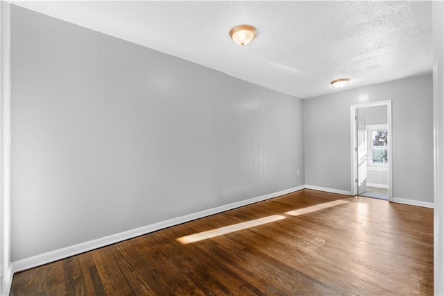 spare room with hardwood / wood-style floors and a textured ceiling