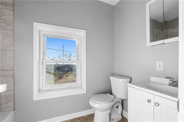 bathroom with tile patterned flooring, vanity, toilet, and a wealth of natural light