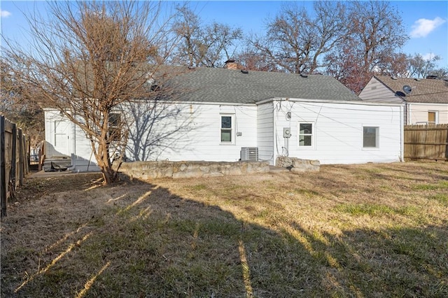 rear view of property with a lawn, cooling unit, and a shed