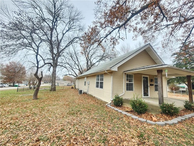 view of home's exterior with a porch, a yard, and central AC