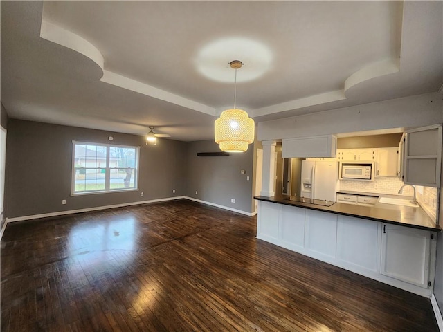 kitchen featuring white appliances, sink, dark hardwood / wood-style floors, ceiling fan, and decorative light fixtures