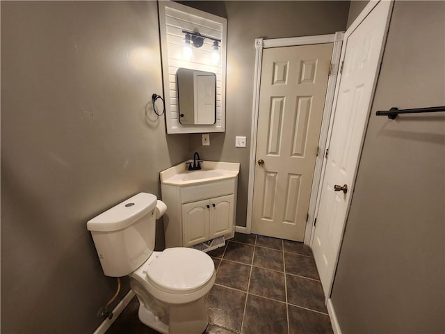 bathroom with toilet, vanity, and tile patterned floors