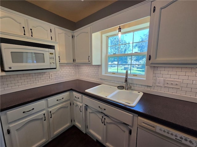909 N Fulton St, Butler, MO 64730 - kitchen featuring white appliances, dark countertops, white cabinets, and backsplash