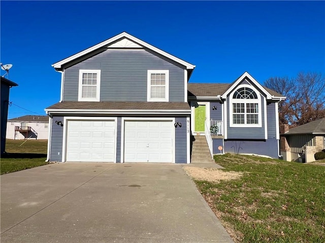 tri-level home featuring a garage and a front lawn