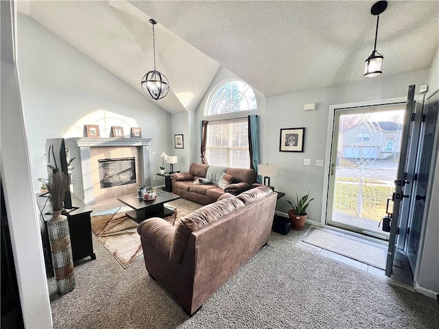 living room featuring carpet, lofted ceiling, a high end fireplace, a textured ceiling, and a chandelier