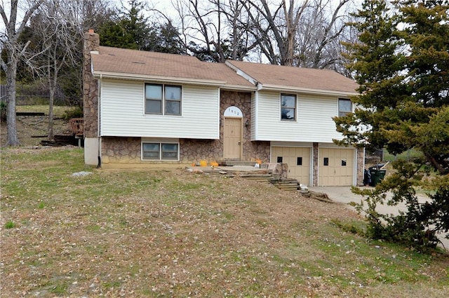 split foyer home with a front lawn and a garage