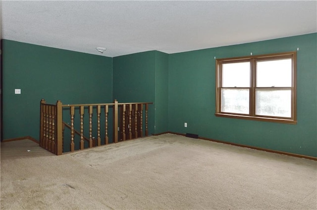 carpeted empty room with a textured ceiling