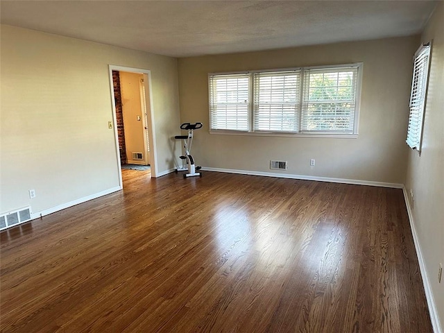 empty room with dark hardwood / wood-style flooring