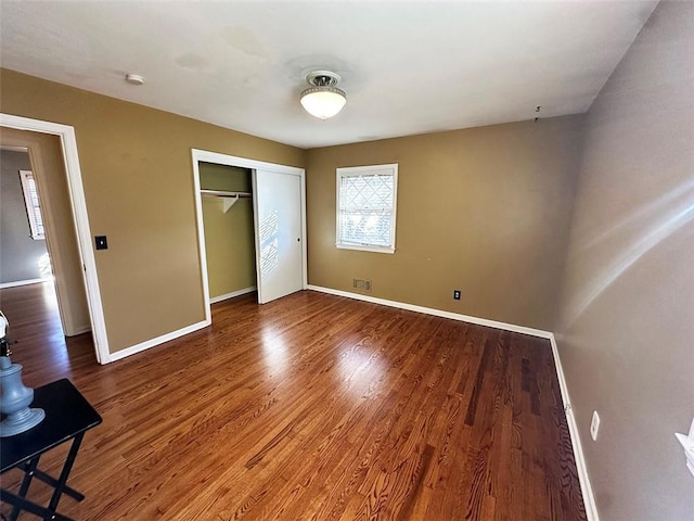 unfurnished bedroom featuring a closet and hardwood / wood-style flooring