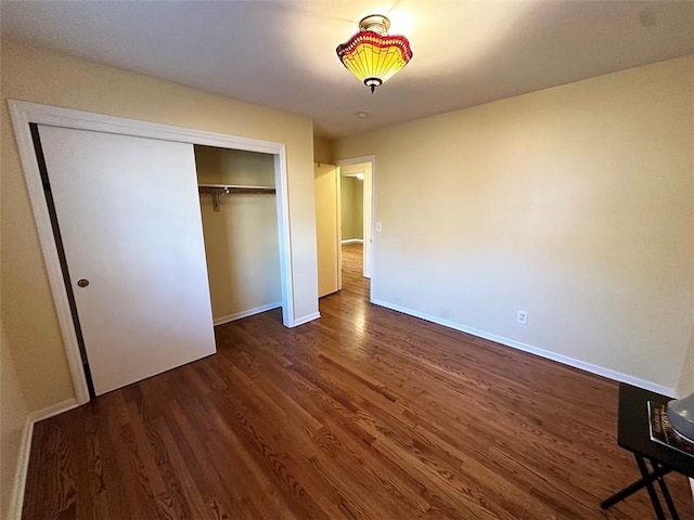 unfurnished bedroom with dark hardwood / wood-style floors and a closet