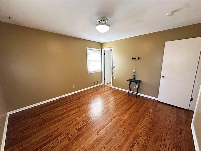 empty room with hardwood / wood-style flooring