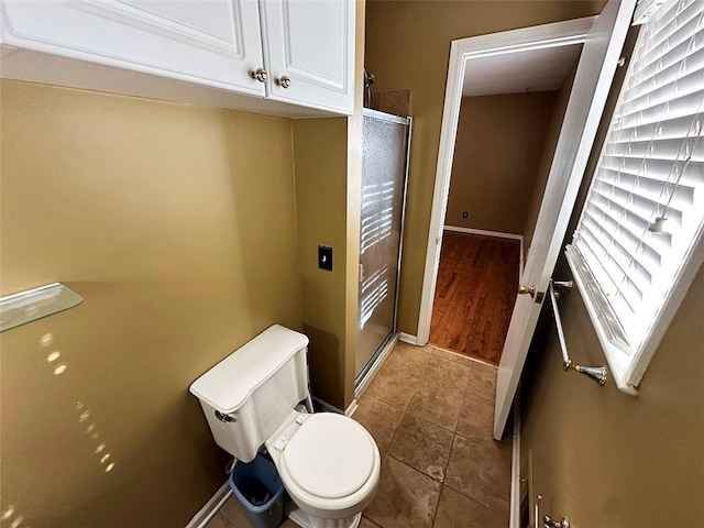 bathroom featuring tile patterned floors, toilet, and walk in shower