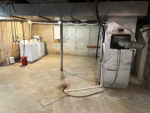 basement featuring heating unit and washer and clothes dryer