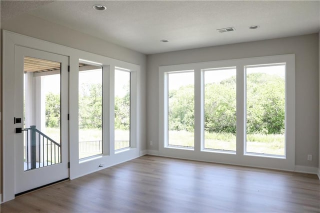 21513 W 80th Ter, Shawnee, KS 66220 - doorway with healthy amount of natural light, wood finished floors, and a textured ceiling