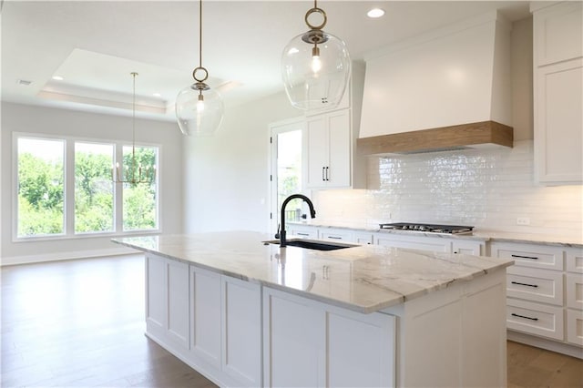 21513 W 80th Ter, Shawnee, KS 66220 - kitchen with custom range hood, decorative backsplash, recessed lighting, white cabinetry, and an island with sink