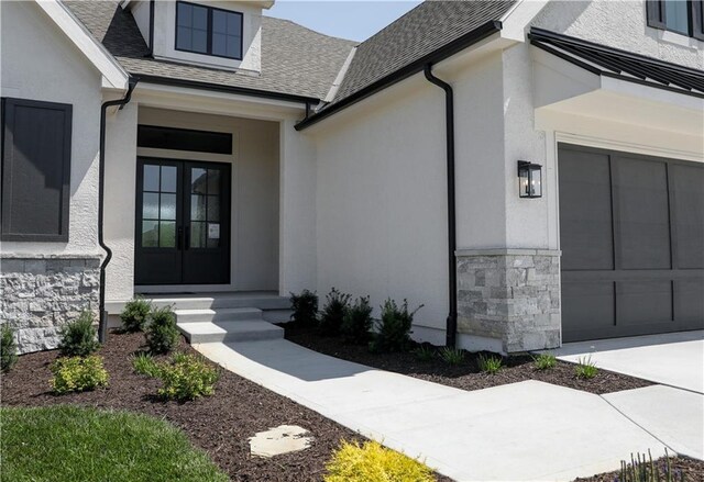 21513 W 80th Ter, Shawnee, KS 66220 - view of exterior entry featuring french doors, stucco siding, stone siding, and a shingled roof