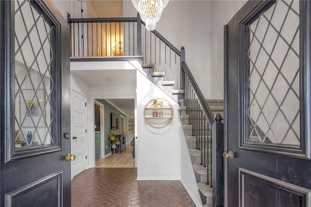 entrance foyer featuring a notable chandelier and a towering ceiling