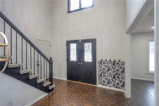 entrance foyer featuring a towering ceiling and a wealth of natural light