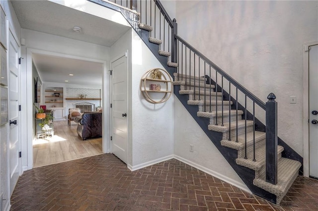 stairway with a brick fireplace