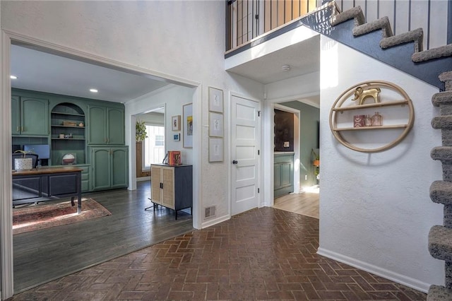 foyer featuring ornamental molding and a high ceiling