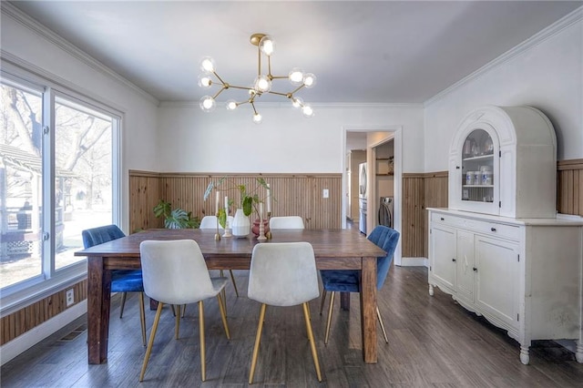 dining room with a notable chandelier, crown molding, and dark wood-type flooring