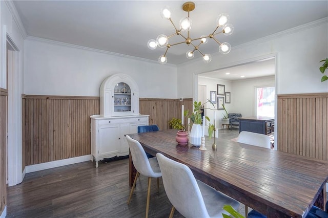 dining room with a notable chandelier, ornamental molding, dark hardwood / wood-style floors, and wood walls