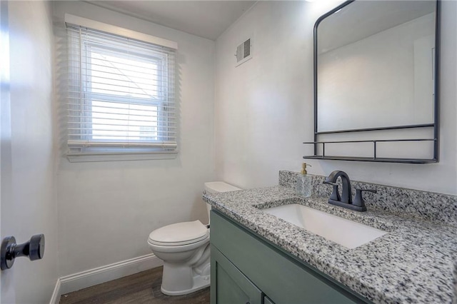 bathroom featuring vanity, hardwood / wood-style floors, and toilet