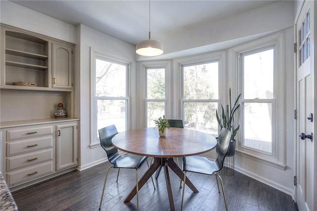 dining area featuring dark wood-type flooring and a healthy amount of sunlight