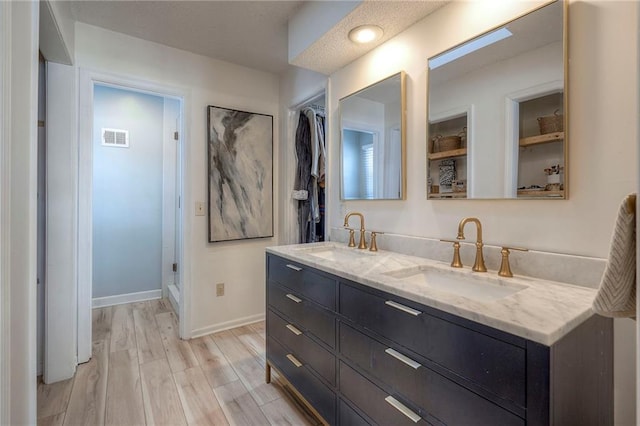 bathroom featuring walk in shower, vanity, and hardwood / wood-style floors