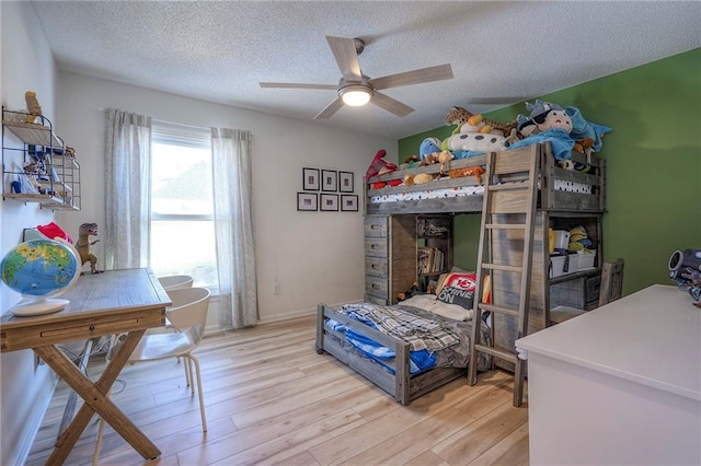 bedroom with ceiling fan, a textured ceiling, and light hardwood / wood-style flooring