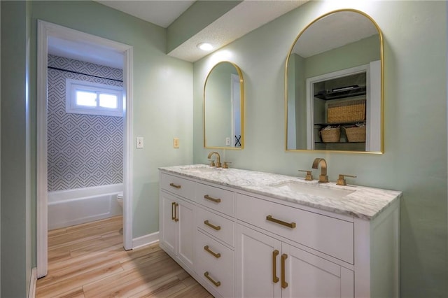 full bathroom featuring vanity, tiled shower / bath, hardwood / wood-style flooring, and toilet