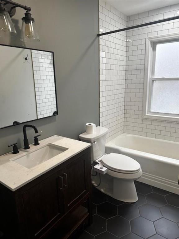 full bathroom with tiled shower / bath, tile patterned flooring, vanity, and toilet