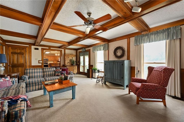 living room featuring ceiling fan, beamed ceiling, light carpet, and coffered ceiling