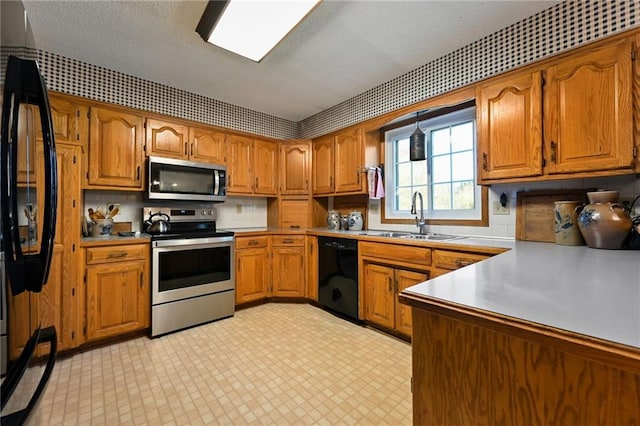 kitchen with a textured ceiling, sink, and black appliances