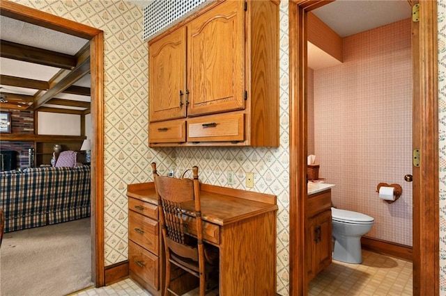 bathroom with beam ceiling and toilet