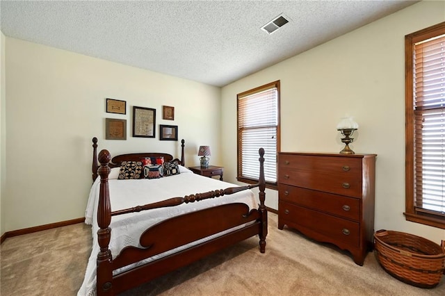 bedroom with light carpet and a textured ceiling