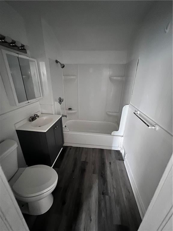 full bathroom featuring hardwood / wood-style flooring, toilet, vanity, and  shower combination