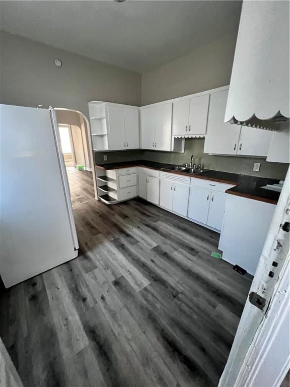 kitchen featuring dark wood-type flooring, white cabinets, white refrigerator, and sink