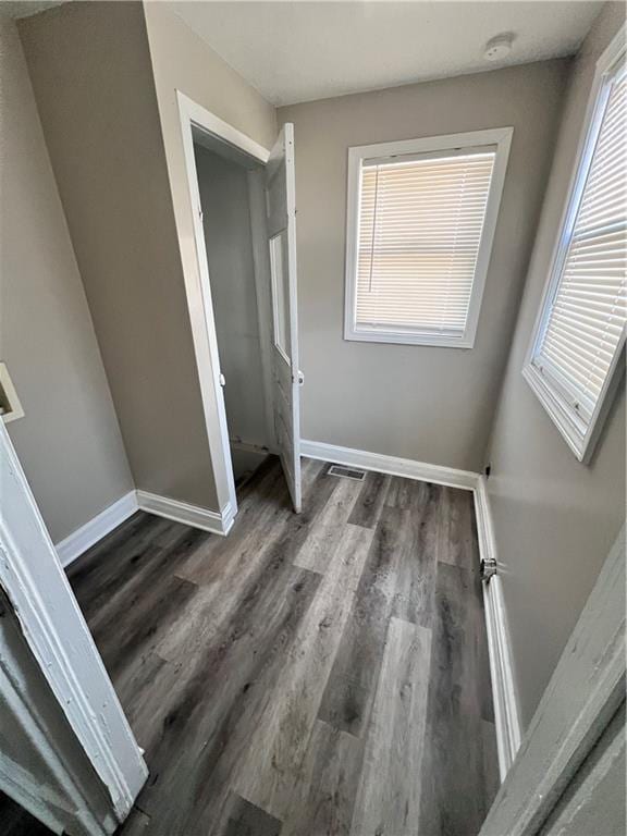 unfurnished bedroom featuring a closet and dark wood-type flooring