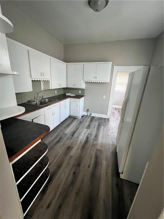 kitchen with dark wood-type flooring, sink, and white cabinets