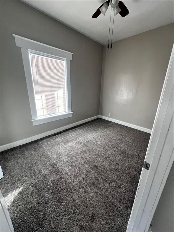 carpeted empty room featuring ceiling fan